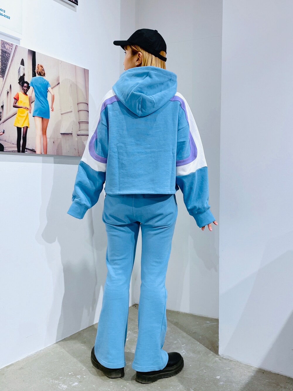 ブルー系のパーカー、ブルー系のスウェットパンツ、ブラック系のキャップを着用したレディースの冬コーディネートの2枚目の写真