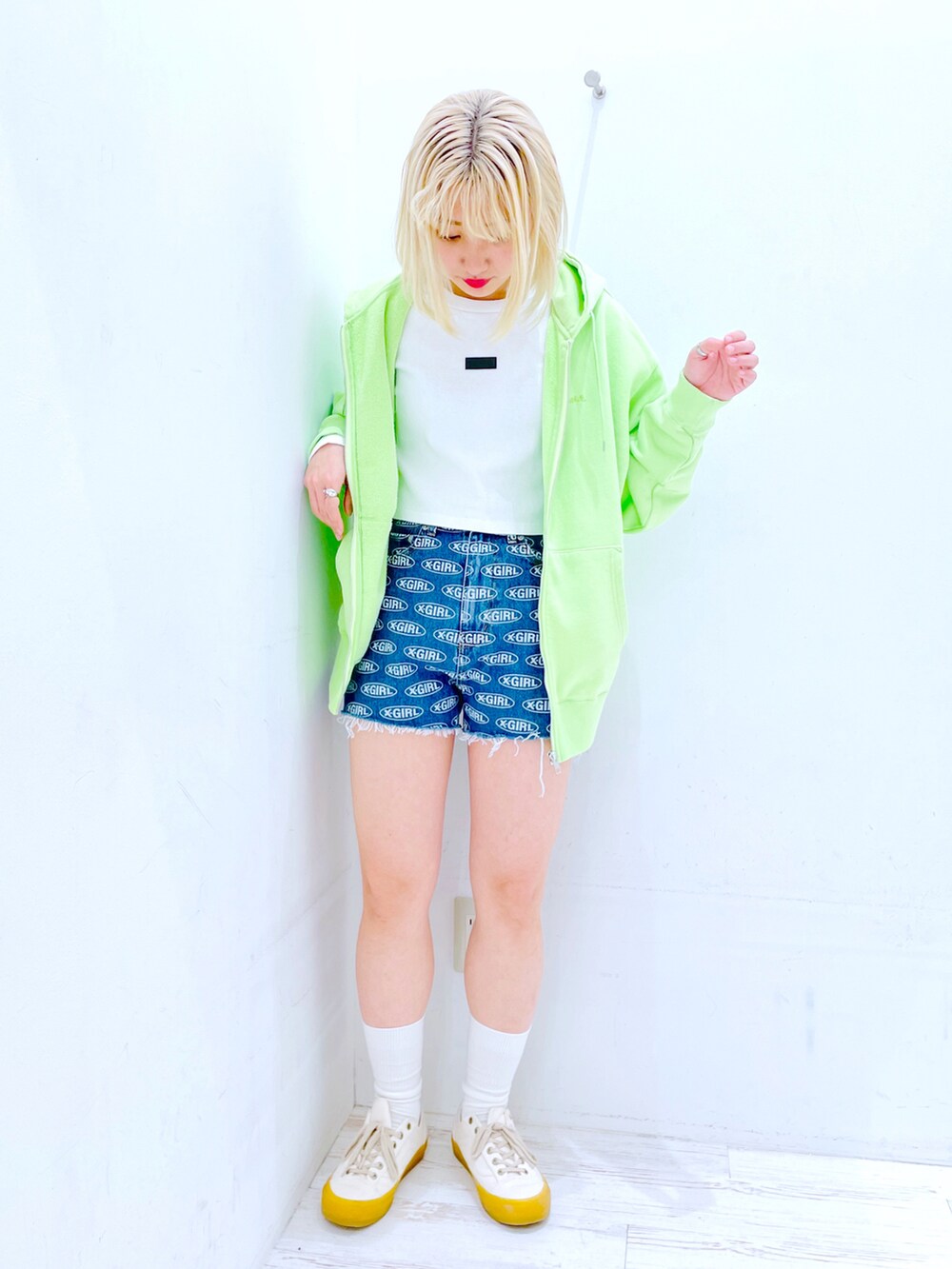 ブルー系のデニムパンツ、ホワイト系のTシャツ/カットソー、グリーン系のパーカーを着用したレディースの春コーディネートの2枚目の写真