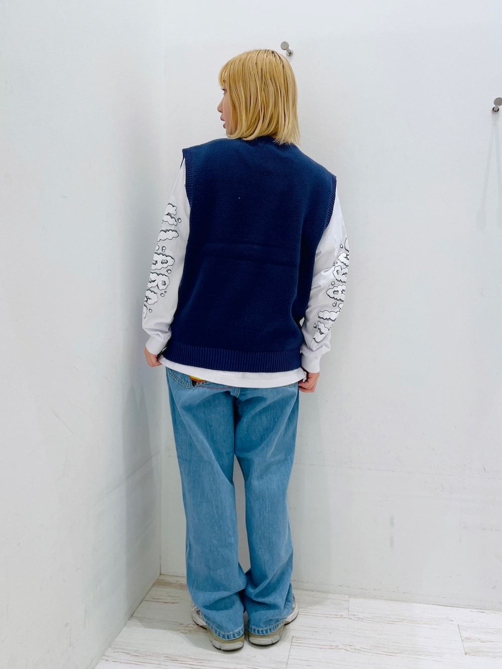 ブルー系のデニムパンツ、ブルー系のベスト、ホワイト系のTシャツ/カットソーを着用したレディースの春コーディネートの2枚目の写真