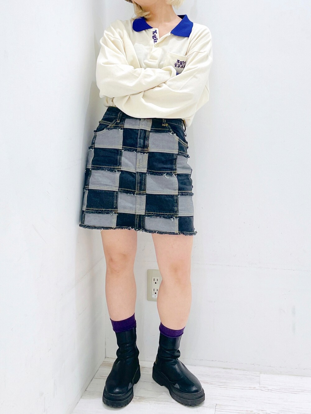 ホワイト系のポロシャツ、ブラック系のデニムスカート、ベージュ系のハンチング/ベレー帽を着用したレディースの春コーディネートの2枚目の写真