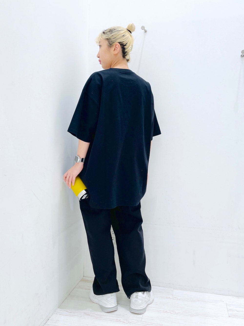 ブラック系のその他パンツ、ブラック系のTシャツ/カットソー、イエロー系のグラス/マグカップ/タンブラーを着用したレディースの春コーディネートの2枚目の写真