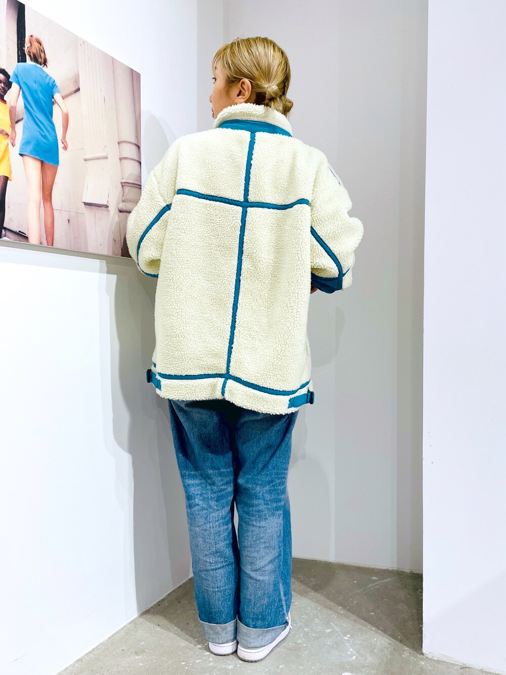 ブルー系のデニムパンツ、ホワイト系のTシャツ/カットソー、ホワイト系のブルゾンを着用したレディースの秋コーディネートの2枚目の写真