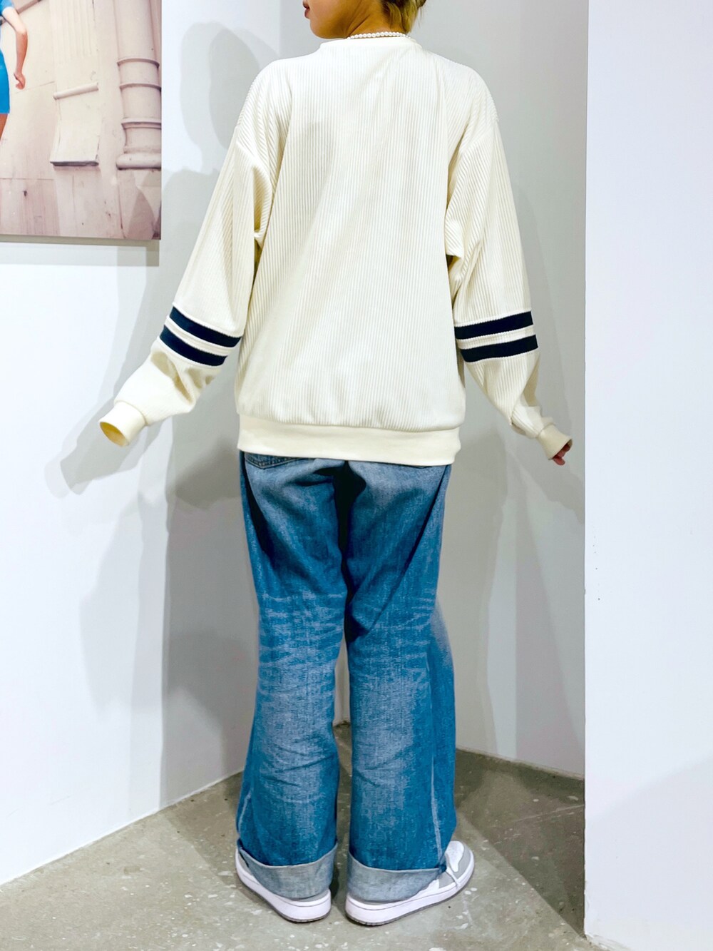 ブルー系のデニムパンツ、ホワイト系のTシャツ/カットソー、ホワイト系のブルゾンを着用したレディースの秋コーディネートの3枚目の写真