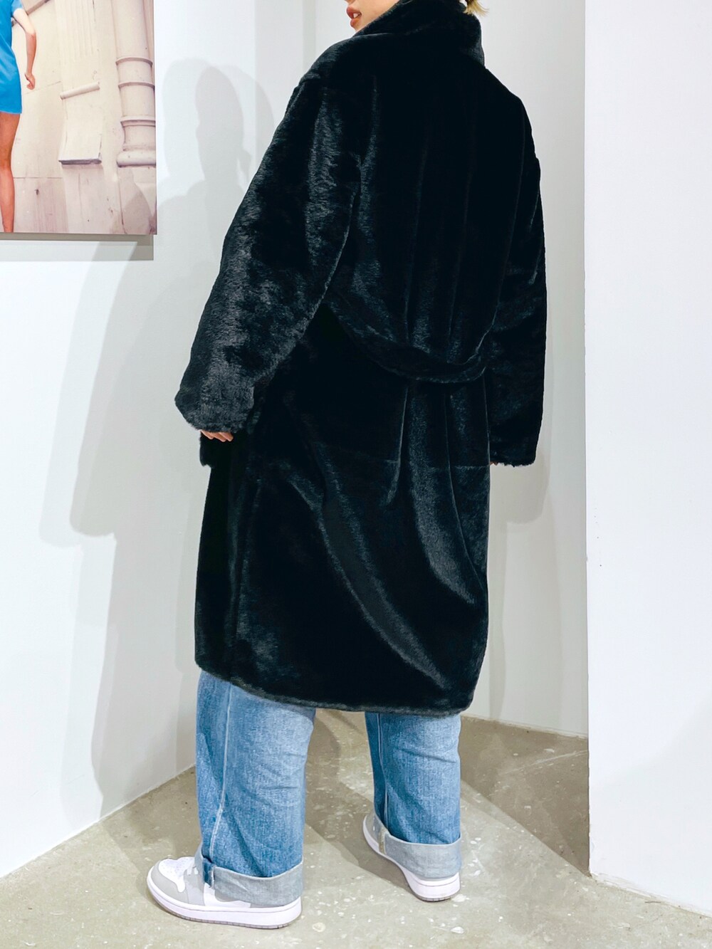 グレー系のスウェット、ブルー系のデニムパンツ、ブラック系のその他アウターを着用したレディースの秋コーディネートの3枚目の写真