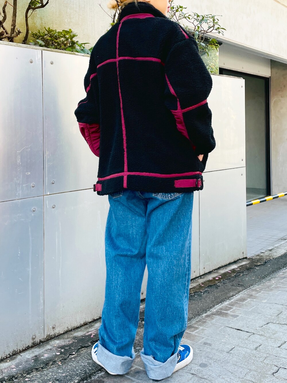 ブルー系のデニムパンツ、ホワイト系のニット/セーター、ブラック系のブルゾンを着用したレディースの秋コーディネートの3枚目の写真