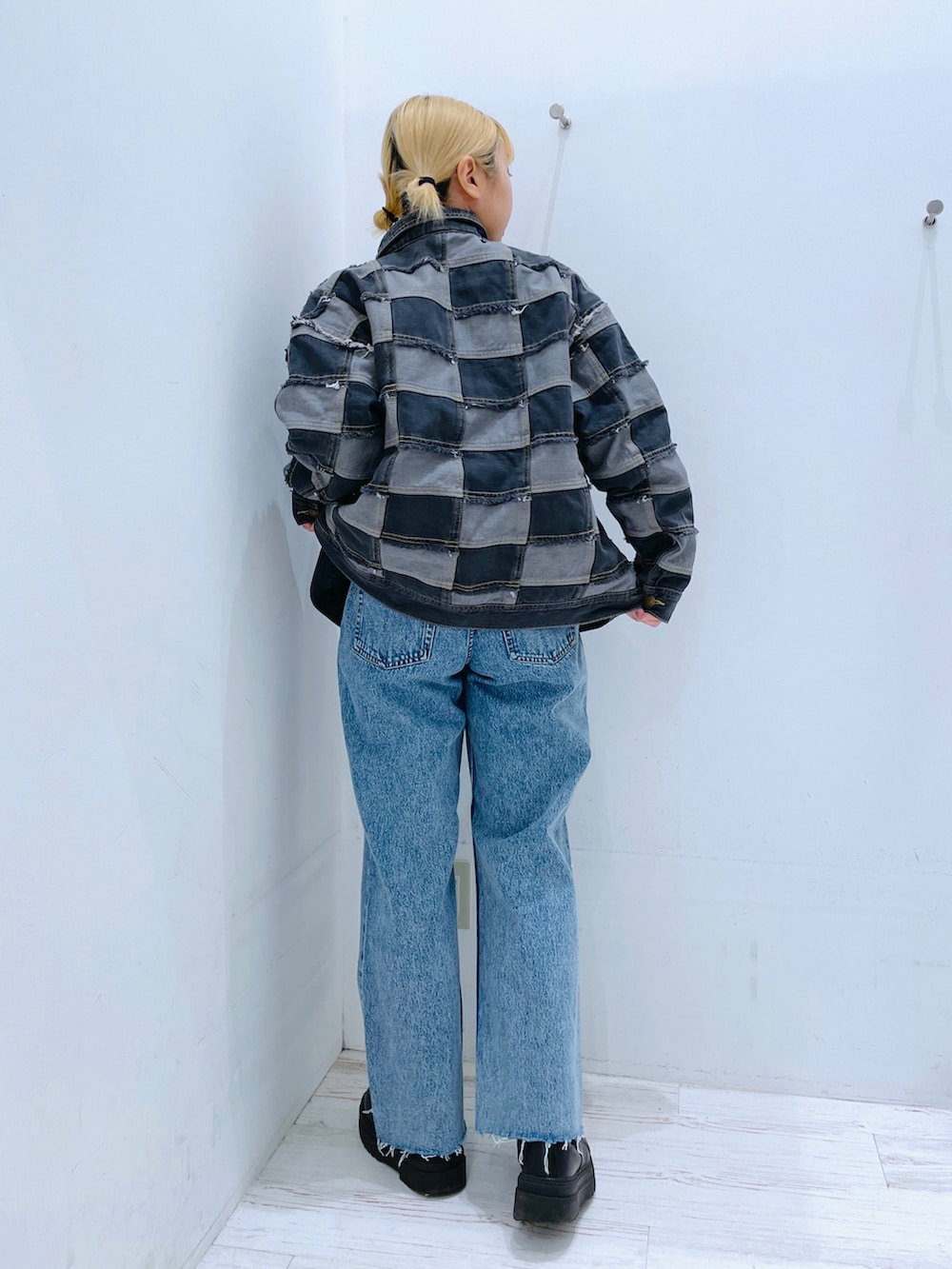 ブルー系のデニムパンツ、ブラック系のデニムジャケットを着用したレディースの春コーディネートの2枚目の写真