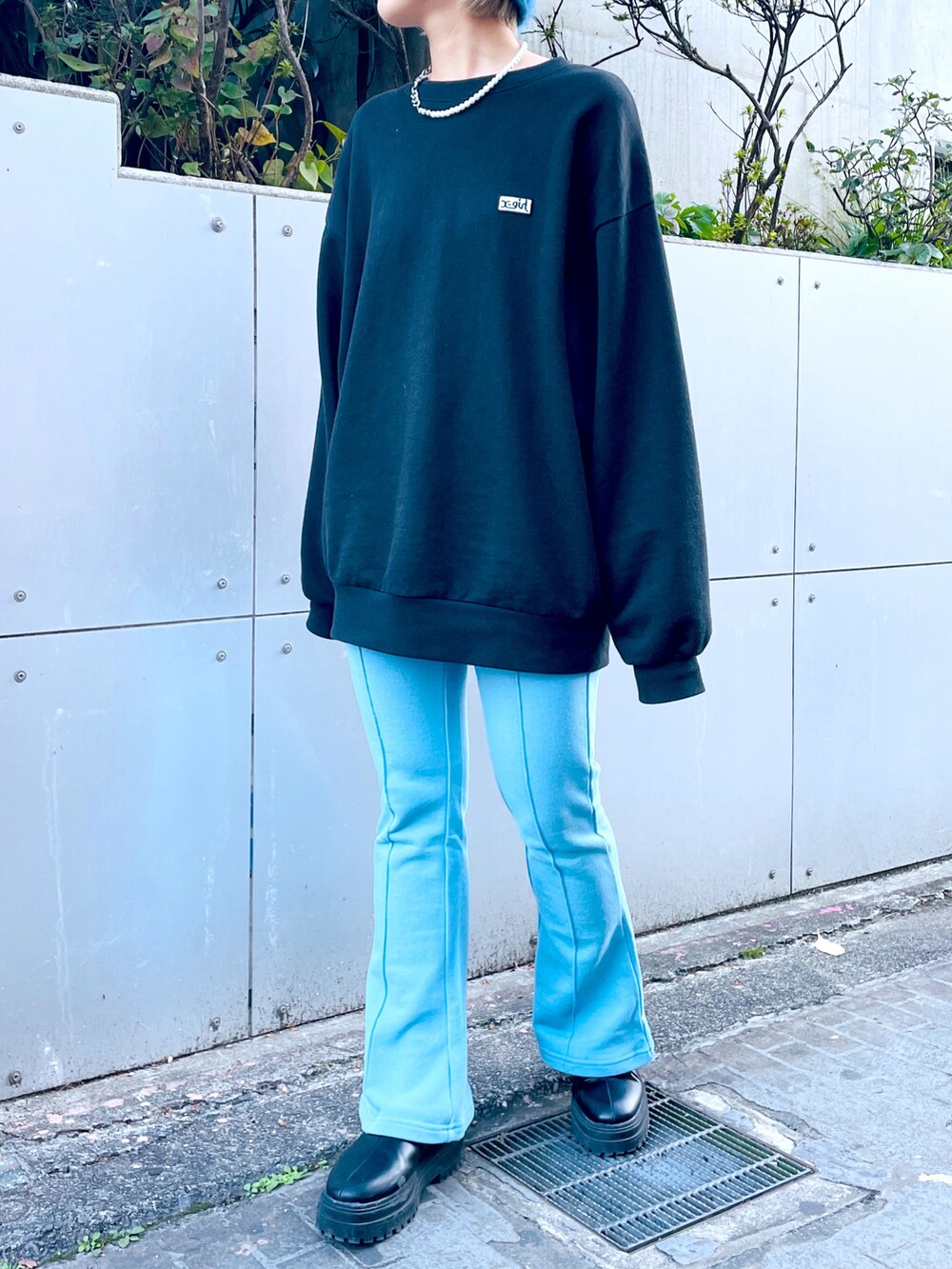 ブラック系のスウェット、ブルー系のスウェットパンツ、ブラック系のブーツを着用したレディースの秋コーディネートの4枚目の写真