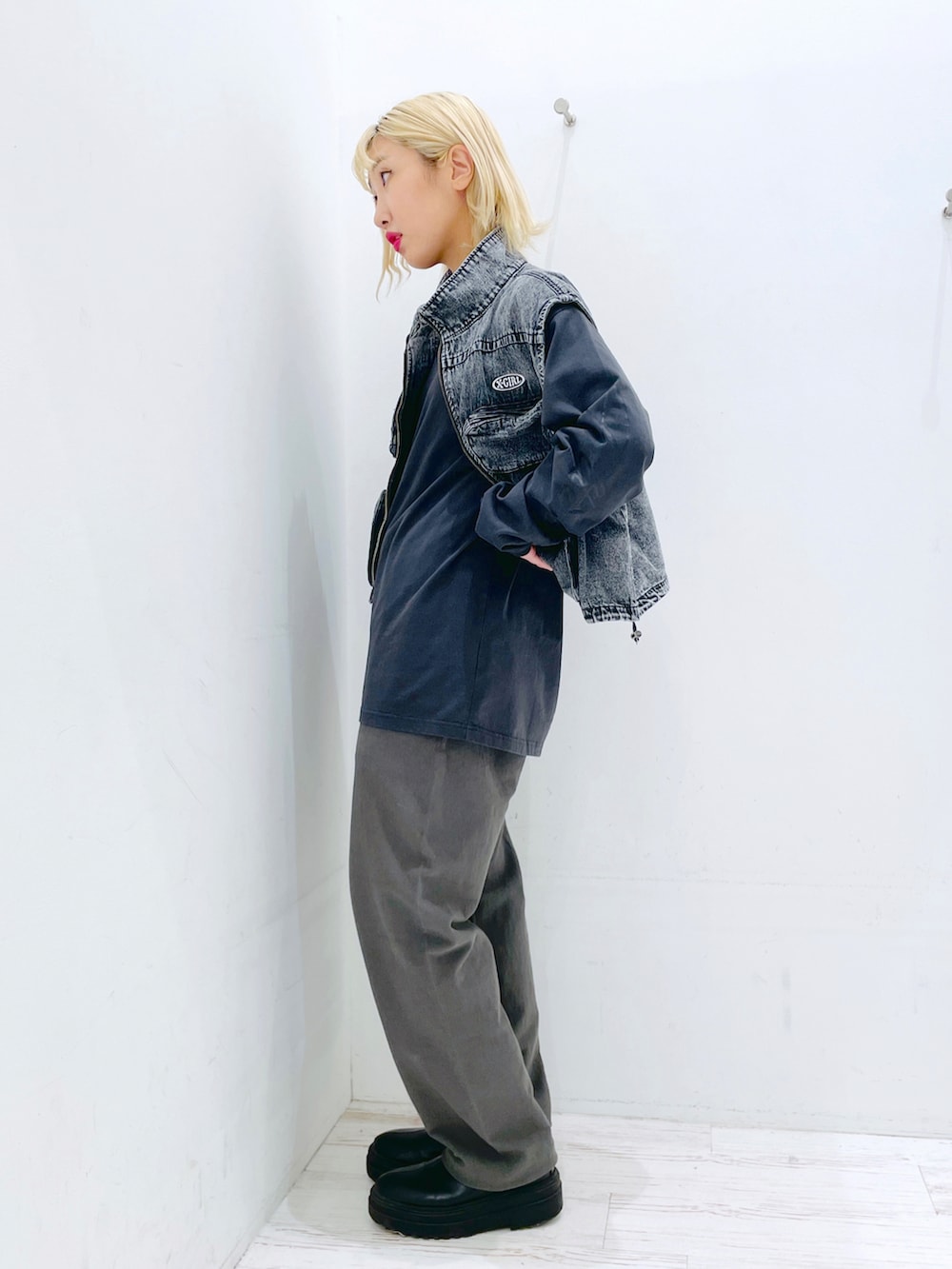 ブラック系のスウェットパンツ、ブラック系のベスト、グレー系のTシャツ/カットソーを着用したレディースの春コーディネートの2枚目の写真