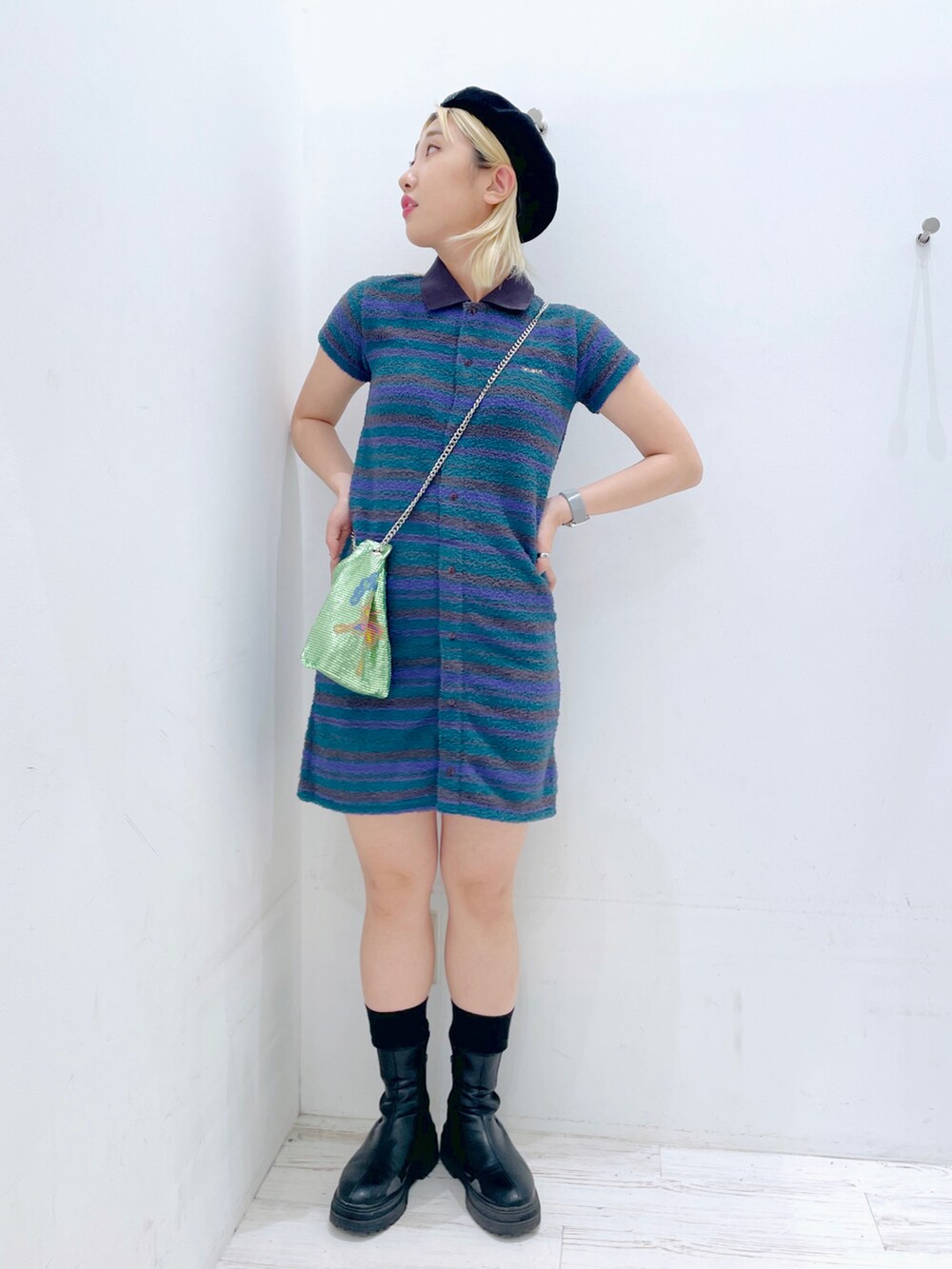 グリーン系のワンピース、グリーン系のショルダーバッグ、ブラック系のハンチング/ベレー帽を着用したレディースの春コーディネートの2枚目の写真