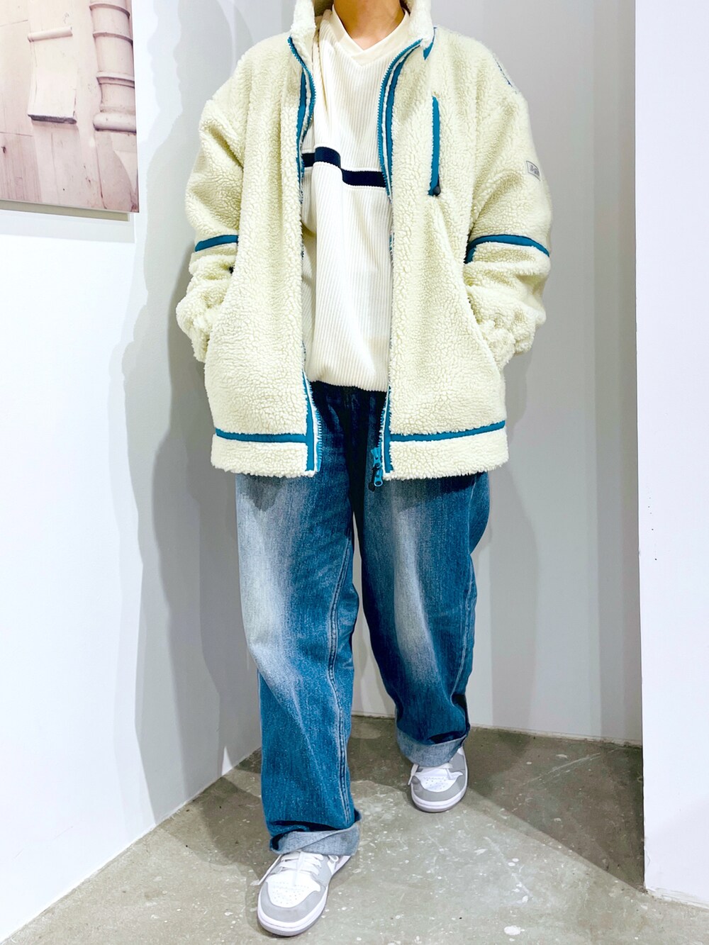 ブルー系のデニムパンツ、ホワイト系のTシャツ/カットソー、ホワイト系のブルゾンを着用したレディースの秋コーディネートの4枚目の写真