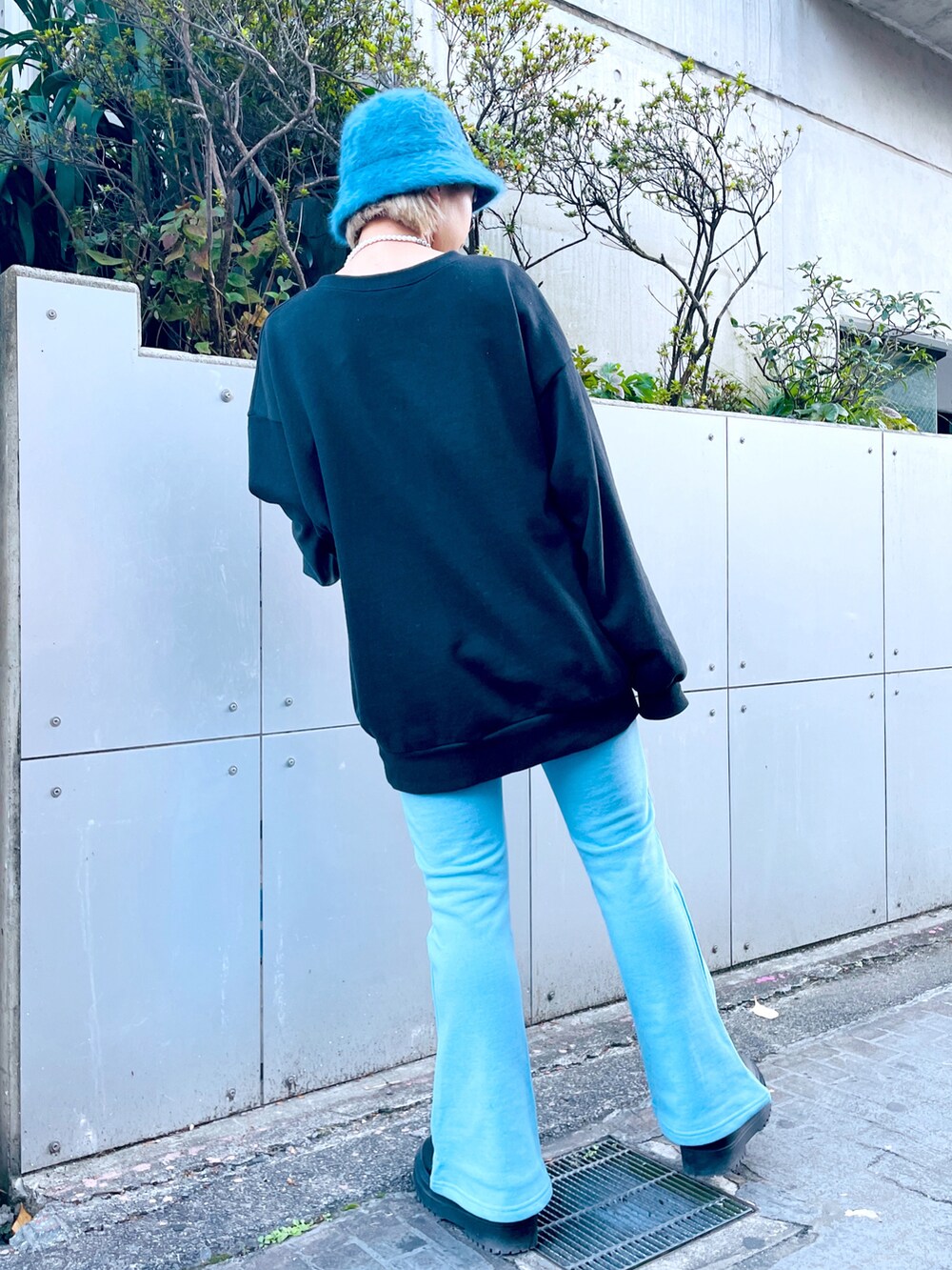 ブラック系のスウェット、ブルー系のスウェットパンツ、ブラック系のブーツを着用したレディースの秋コーディネートの3枚目の写真