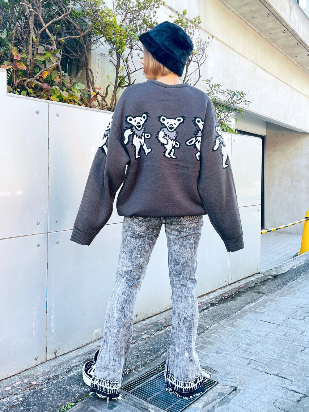 グレー系のニット/セーター、ブラック系のデニムパンツ、ブラック系のハットを着用したレディースの秋コーディネートの4枚目の写真