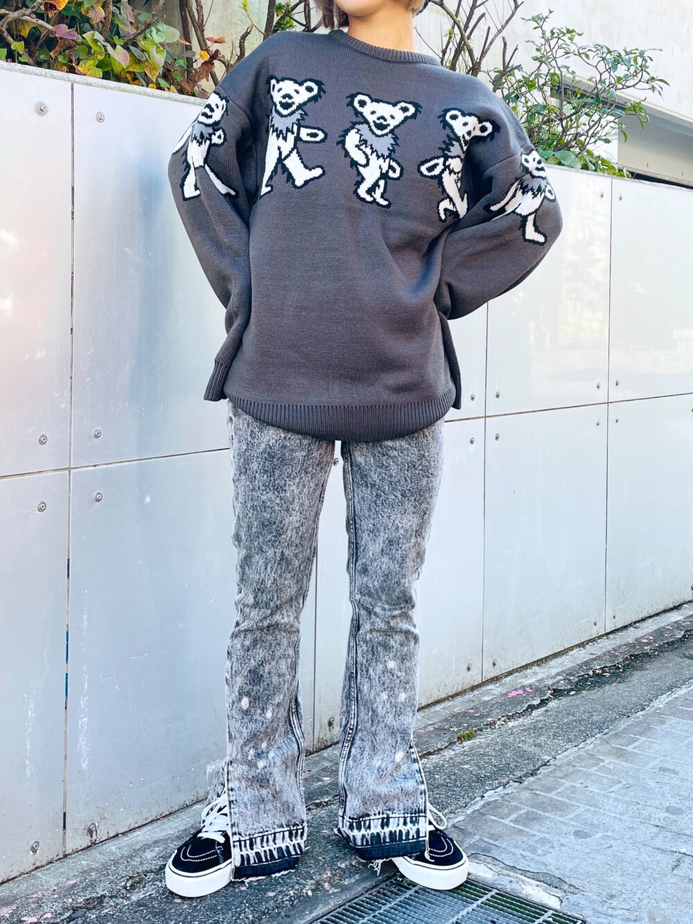 グレー系のニット/セーター、ブラック系のデニムパンツ、ブラック系のハットを着用したレディースの秋コーディネートの2枚目の写真