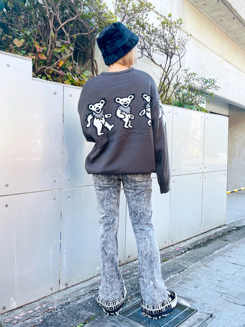 グレー系のニット/セーター、ブラック系のデニムパンツ、ブラック系のハットを着用したレディースの秋コーディネートの3枚目の写真