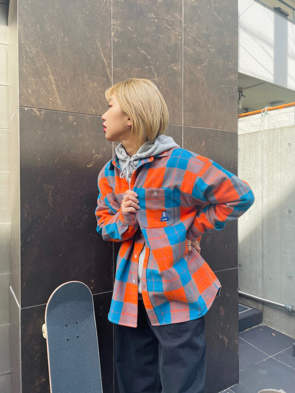 グレー系のパーカー、オレンジ系のシャツ/ブラウス、ブラック系のその他パンツを着用したレディースの冬コーディネートの3枚目の写真