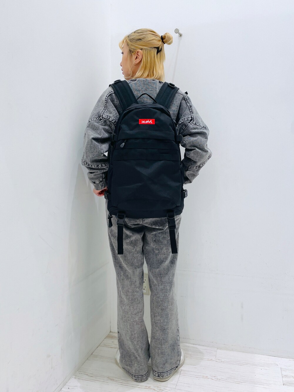 グリーン系のスウェットパンツ、レッド系のバックパック/リュック、ブラック系のスウェットを着用したレディースの春コーディネートの2枚目の写真