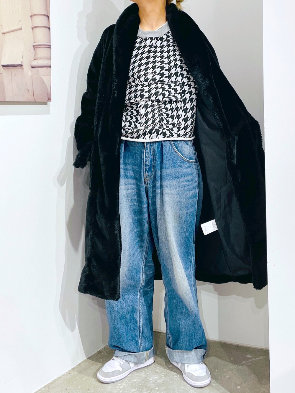 グレー系のスウェット、ブルー系のデニムパンツ、ブラック系のその他アウターを着用したレディースの秋コーディネートの4枚目の写真