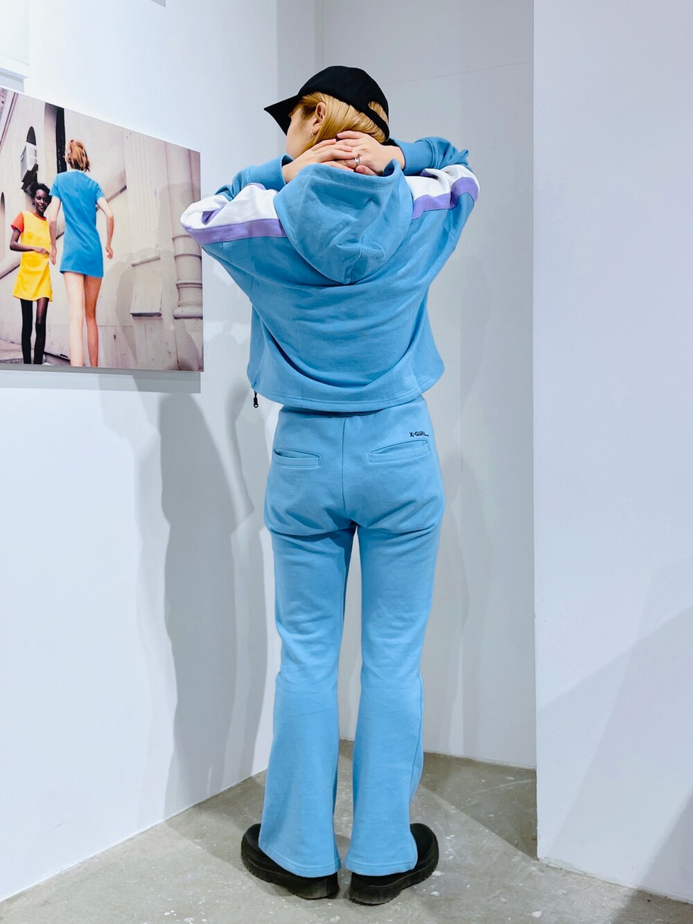 ブルー系のパーカー、ブルー系のスウェットパンツ、ブラック系のキャップを着用したレディースの冬コーディネートの3枚目の写真