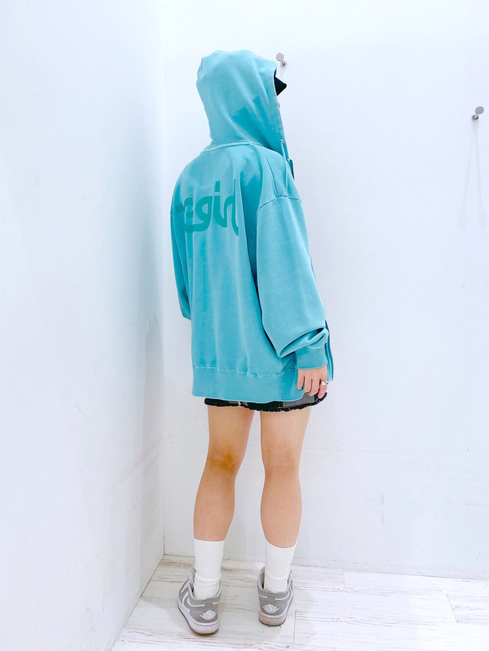 ブラック系のデニムスカート、レッド系のタンクトップ、グリーン系のパーカーを着用したレディースの春コーディネートの2枚目の写真