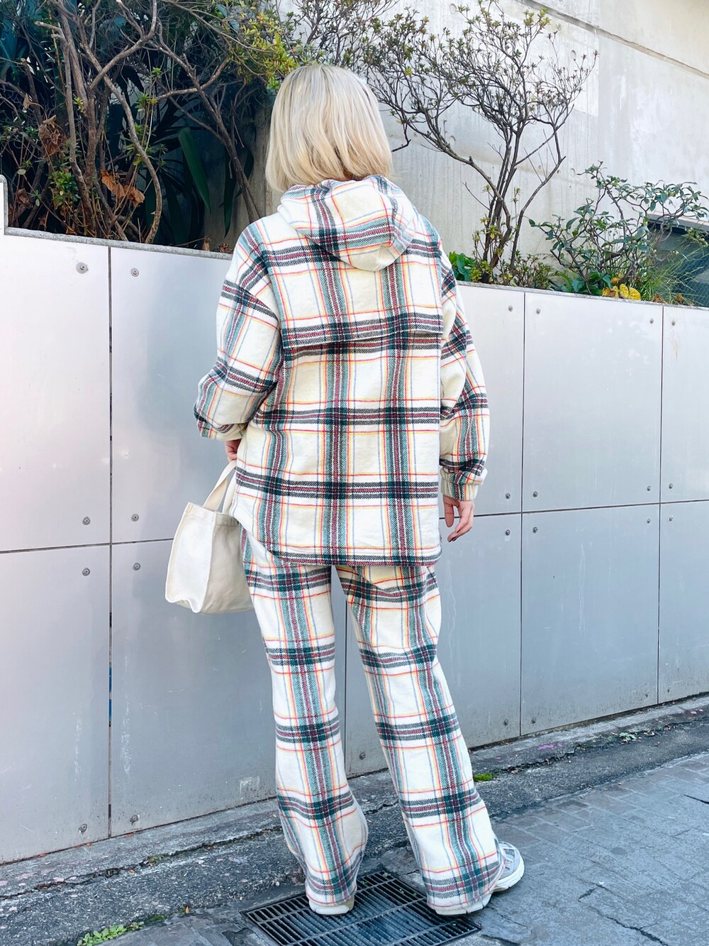 ホワイト系のパーカー、ホワイト系のその他パンツ、ホワイト系のトートバッグを着用したレディースの冬コーディネートの3枚目の写真