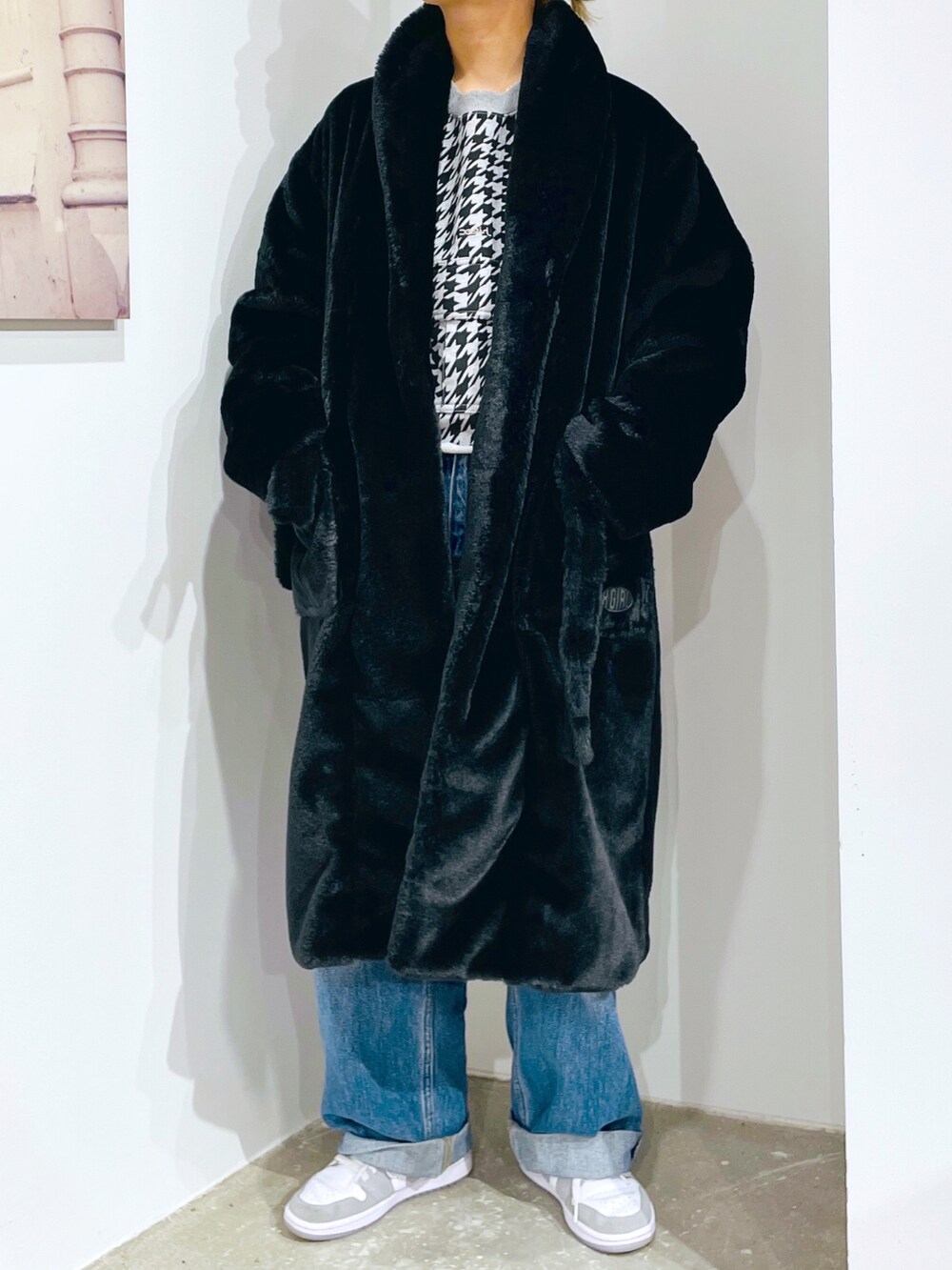 グレー系のスウェット、ブルー系のデニムパンツ、ブラック系のその他アウターを着用したレディースの秋コーディネートの2枚目の写真