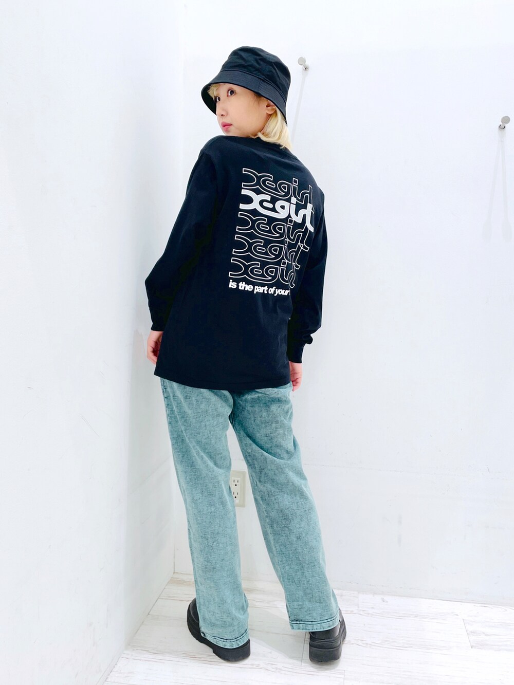 グリーン系のスウェットパンツ、ブラック系のTシャツ/カットソー、ブラック系のハットを着用したレディースの春コーディネートの2枚目の写真