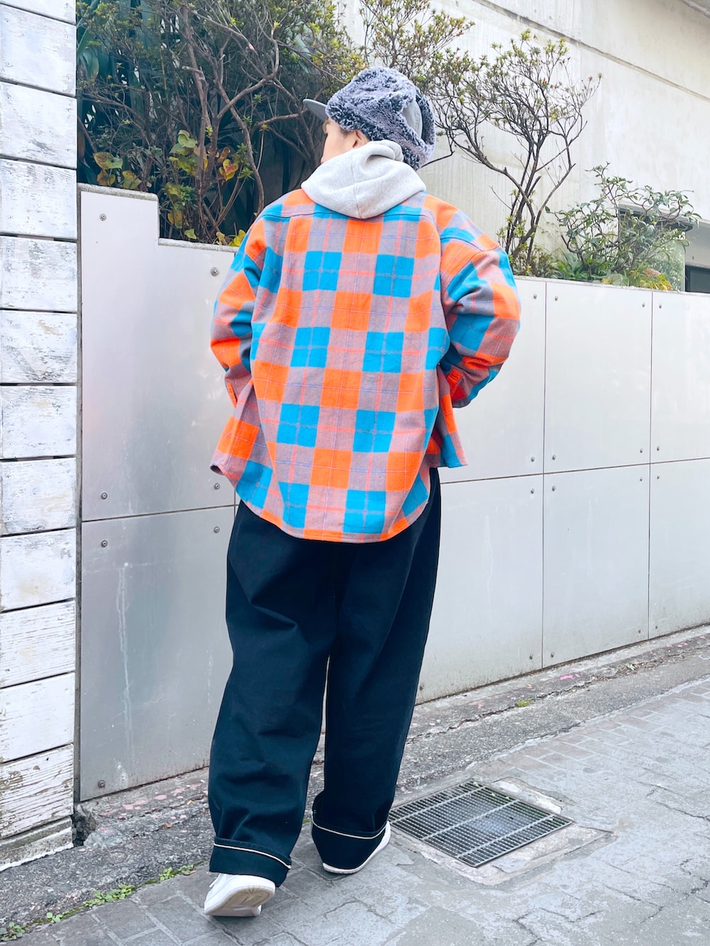 グレー系のパーカー、オレンジ系のシャツ/ブラウス、ブラック系のその他パンツを着用したレディースの秋コーディネートの2枚目の写真