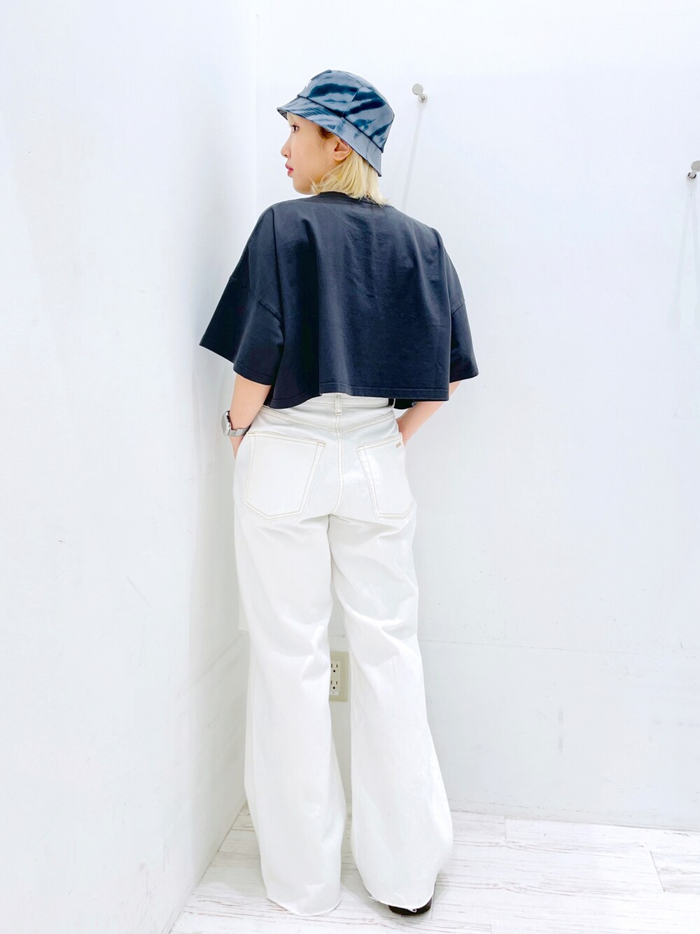 ホワイト系のデニムパンツ、ホワイト系のTシャツ/カットソー、ブラック系のハットを着用したレディースの春コーディネートの2枚目の写真