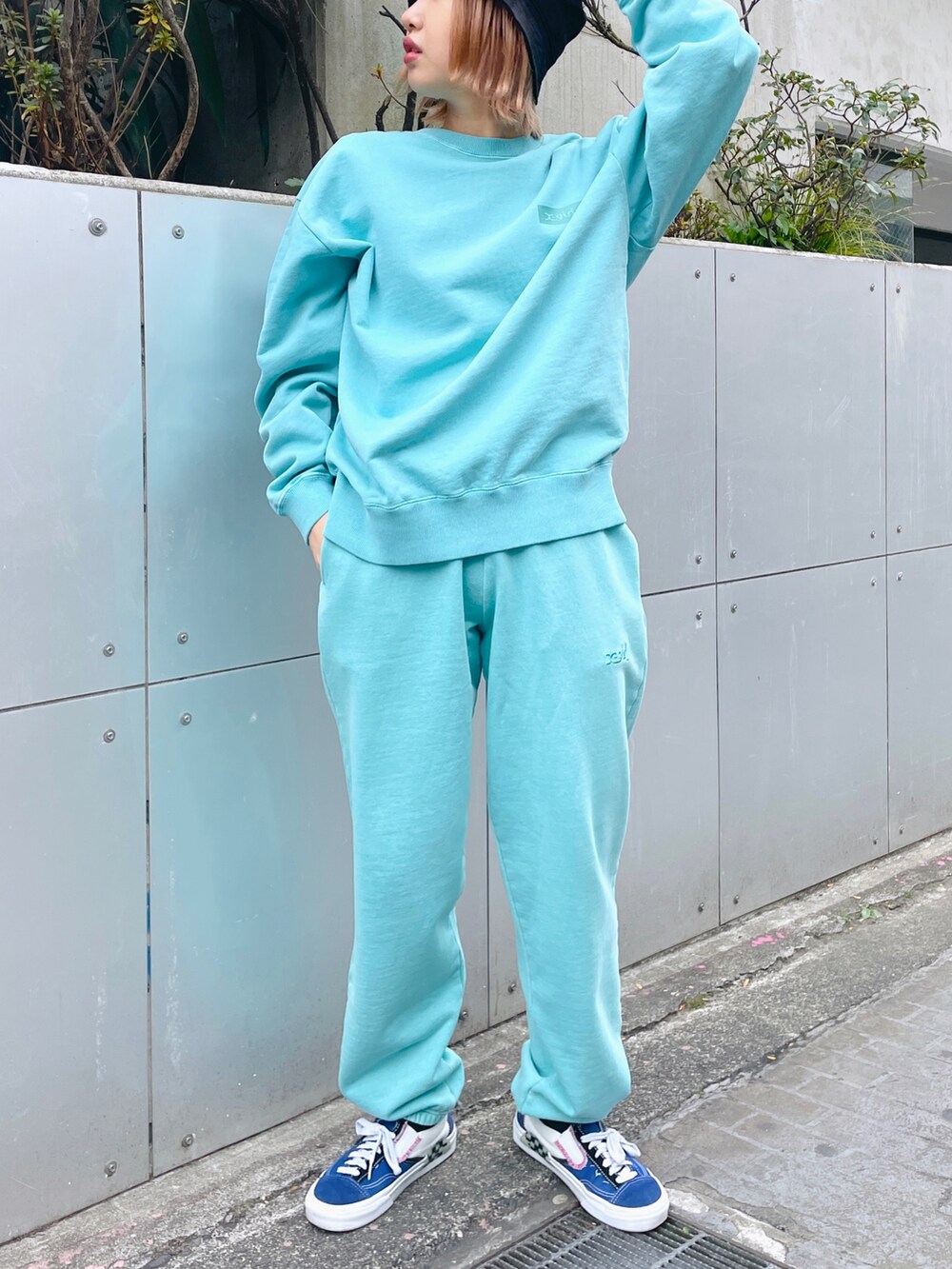 グリーン系のスウェット、グリーン系のスウェットパンツ、ブラック系のハットを着用したレディースの冬コーディネートの3枚目の写真