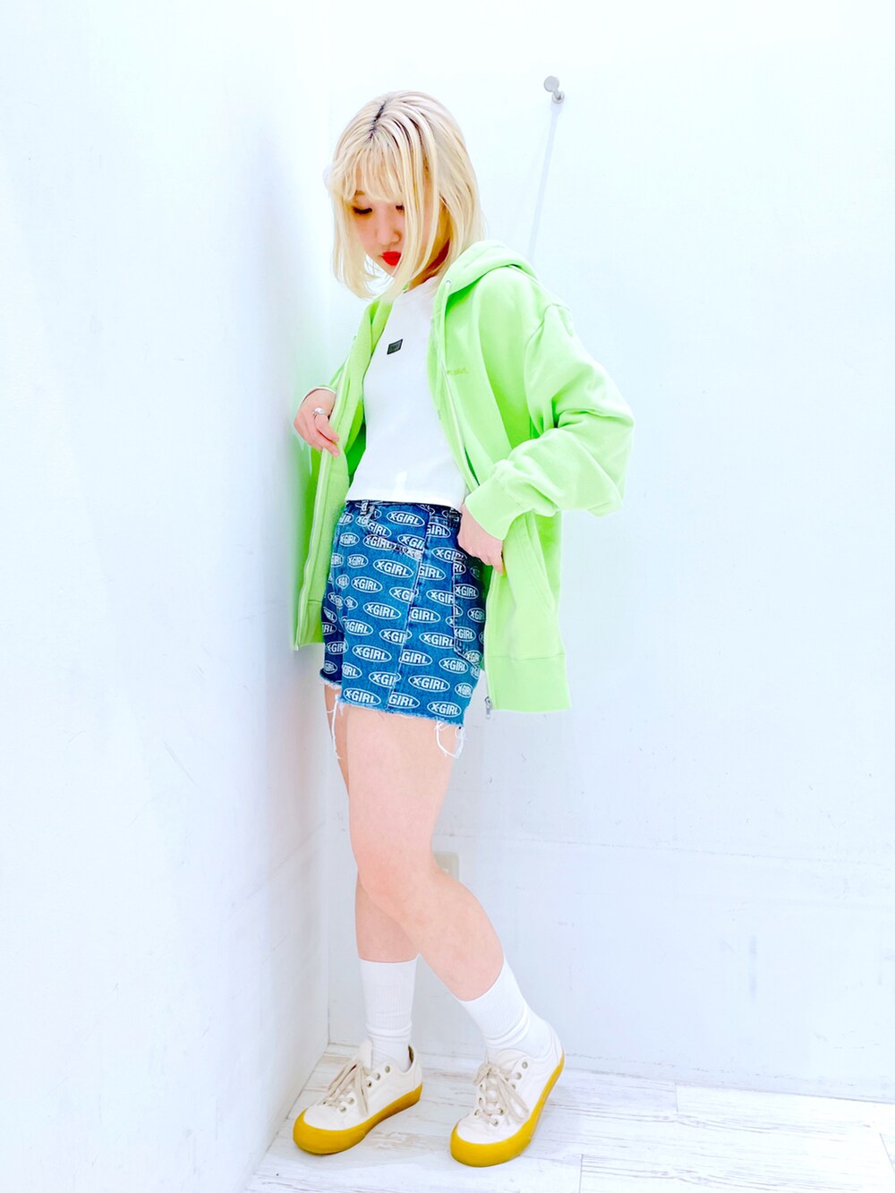 ブルー系のデニムパンツ、ホワイト系のTシャツ/カットソー、グリーン系のパーカーを着用したレディースの春コーディネートの3枚目の写真