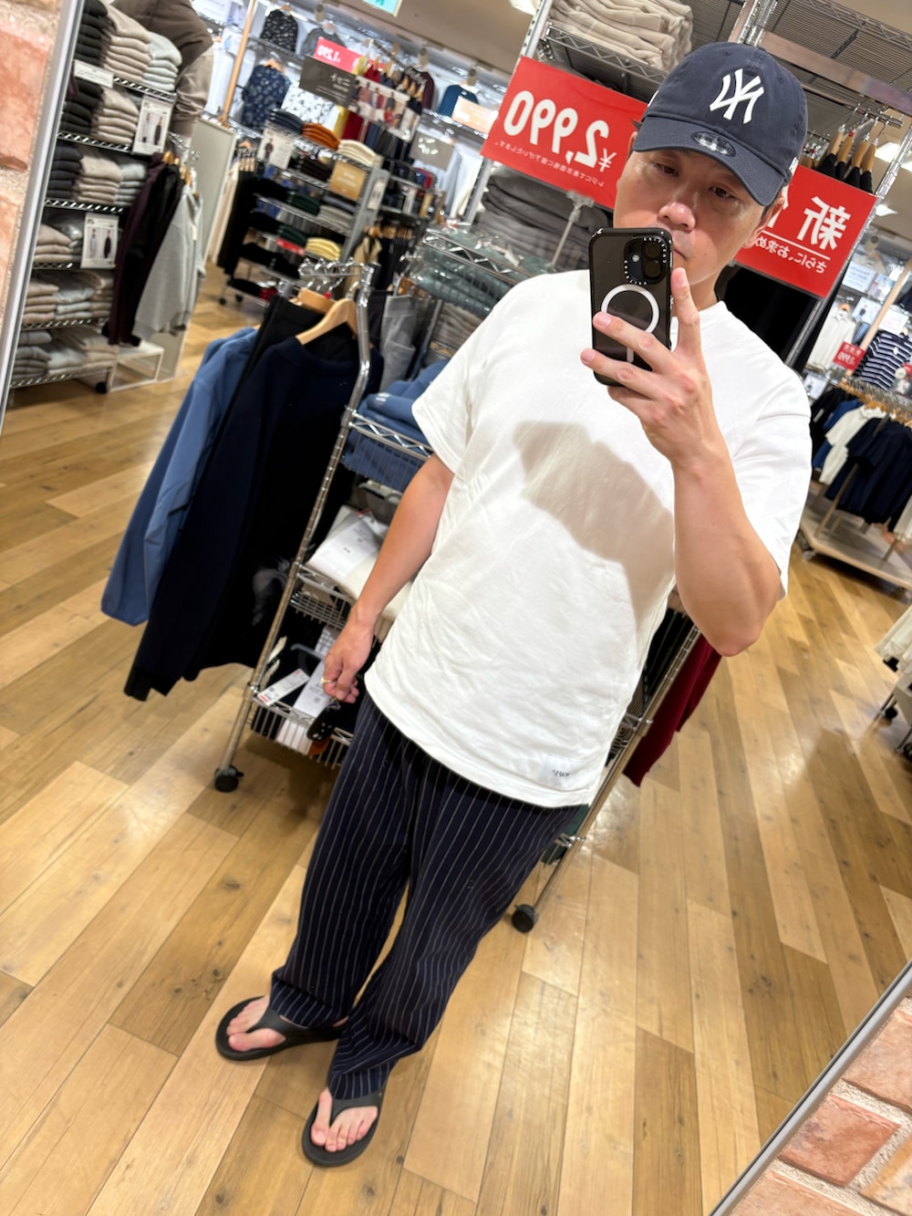 ブルー系のその他パンツ、ホワイト系のTシャツ/カットソー、ブラック系のサンダルを着用したメンズの夏コーディネートの2枚目の写真