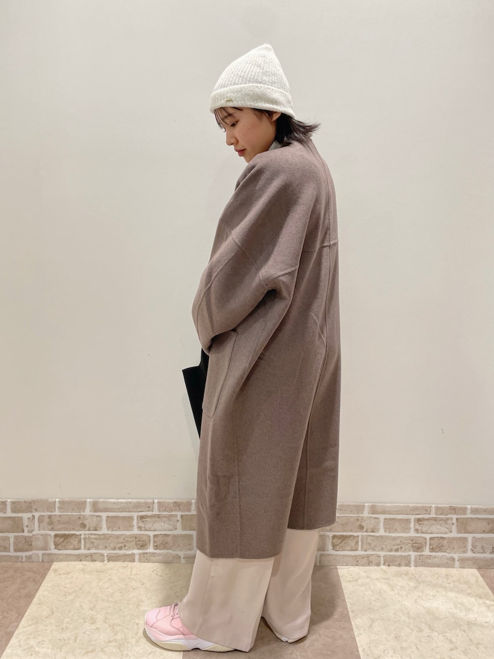 ブラウン系のその他アウター、グレー系のニット/セーター、ベージュ系のパンツを着用したレディースの冬コーディネートの2枚目の写真