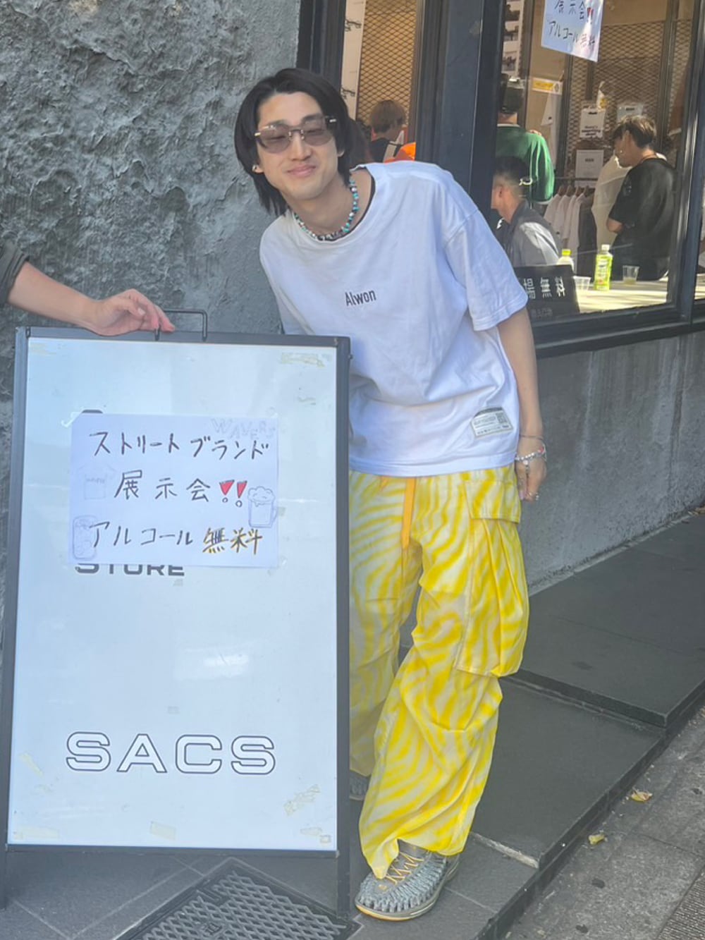 ホワイト系のTシャツ/カットソー、イエロー系のパンツ、グレー系のサンダルを着用したメンズの夏コーディネートの2枚目の写真