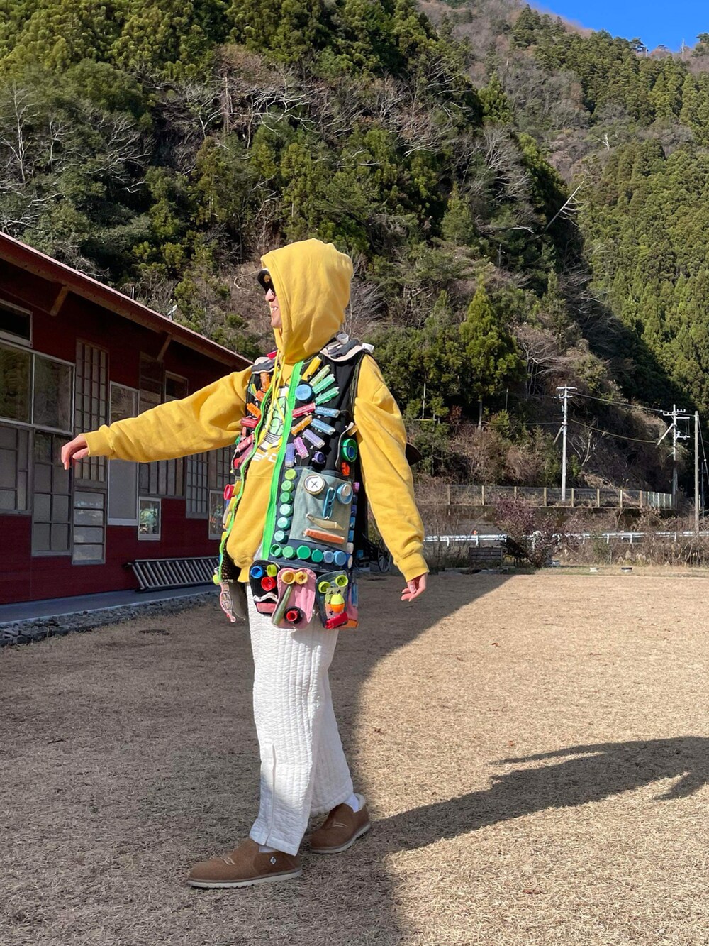 ホワイト系のその他パンツ、イエロー系のパーカー、ブラウン系のブーツを着用したメンズの春コーディネートの3枚目の写真