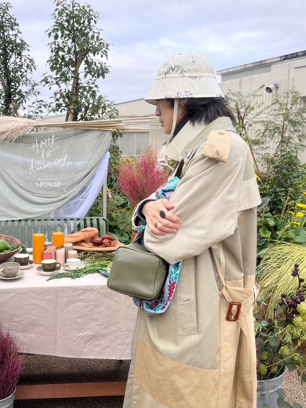 ベージュ系のトレンチコート、ブラウン系のブーツ、グレー系のパンツを着用したメンズの冬コーディネートの3枚目の写真