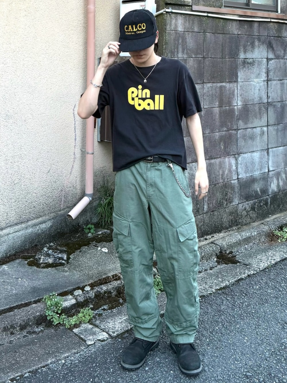 ブラック系のブーツ、ブラック系のTシャツ/カットソー、グリーン系のカーゴパンツを着用したメンズの夏コーディネートの2枚目の写真
