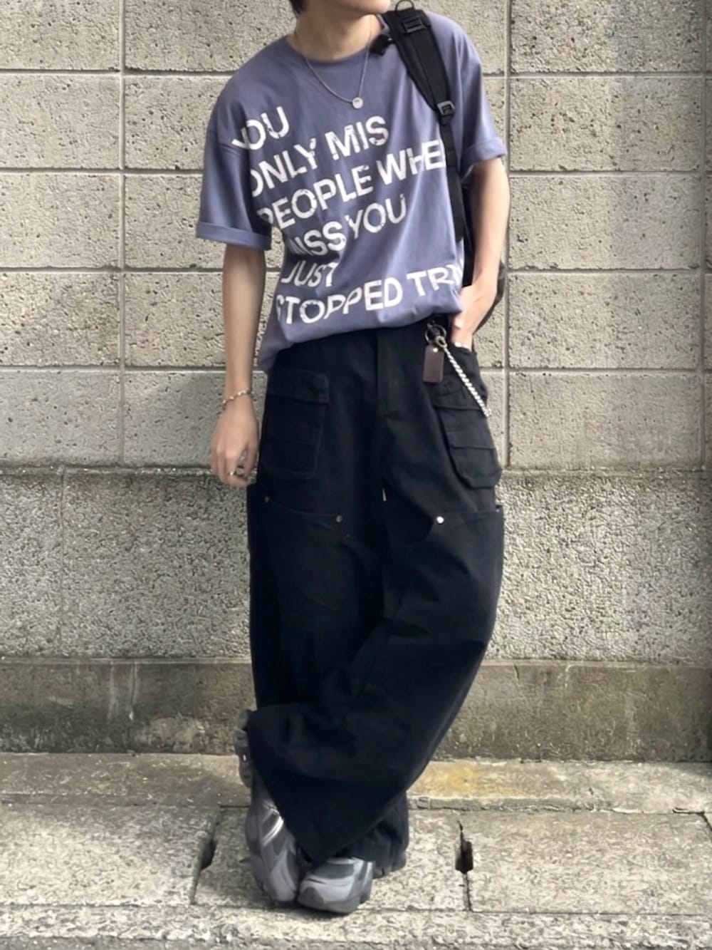 グレー系のスニーカー、ブルー系のTシャツ/カットソー、グリーン系のカーゴパンツを着用したメンズの夏コーディネートの3枚目の写真