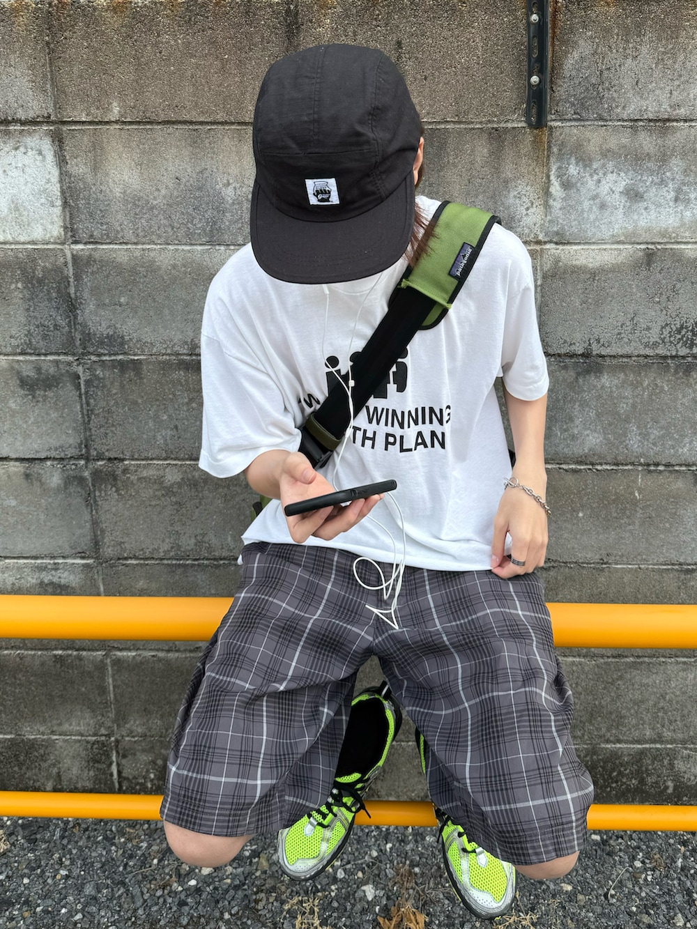 ホワイト系のTシャツ/カットソー、グレー系のパンツ、グリーン系のスニーカーを着用したメンズの夏コーディネートの3枚目の写真