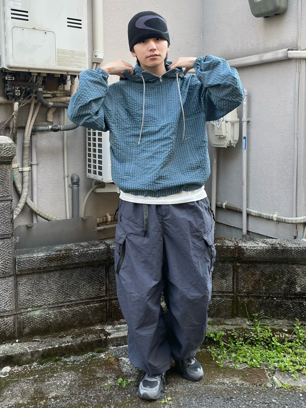 ブルー系のパーカー、グレー系のカーゴパンツ、グレー系のスニーカーを着用したメンズの春コーディネートの2枚目の写真