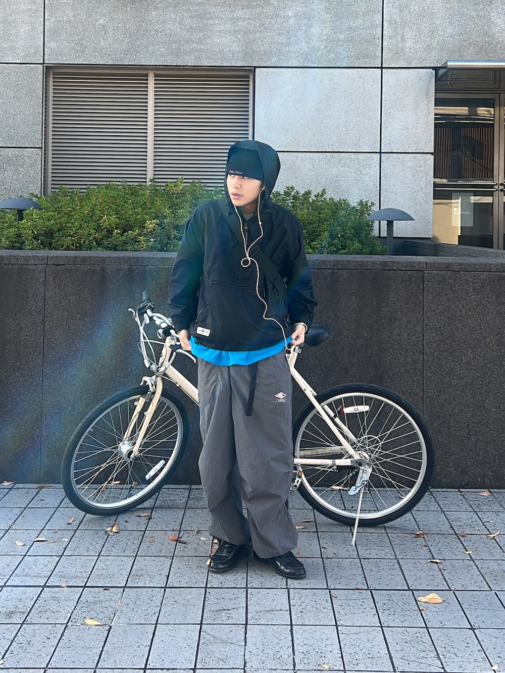 ブラック系のマウンテンパーカー、グレー系のパンツ、ブラック系のローファーを着用したメンズの秋コーディネートの3枚目の写真