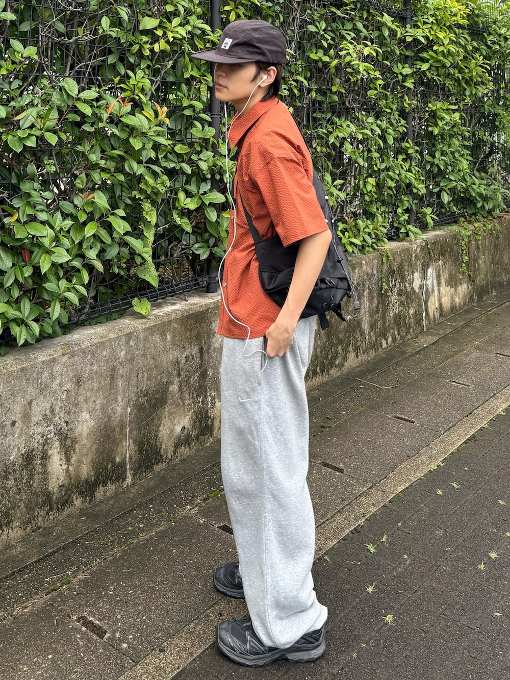 オレンジ系のシャツ/ブラウス、グレー系のスウェットパンツ、ブラック系のスニーカーを着用したメンズの夏コーディネートの2枚目の写真