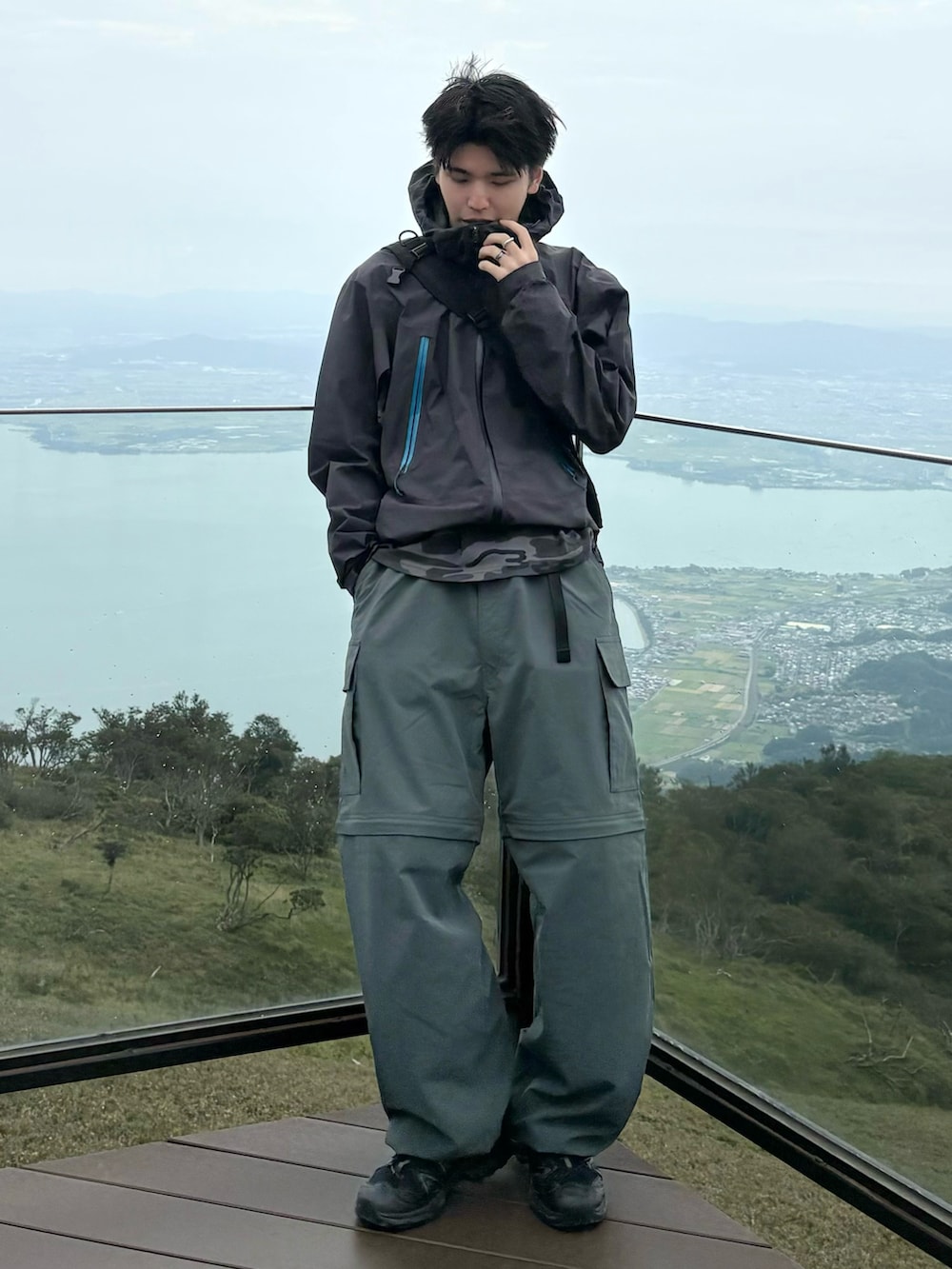 グレー系のTシャツ/カットソー、グレー系のマウンテンパーカー、グリーン系のカーゴパンツを着用したメンズの秋コーディネートの2枚目の写真