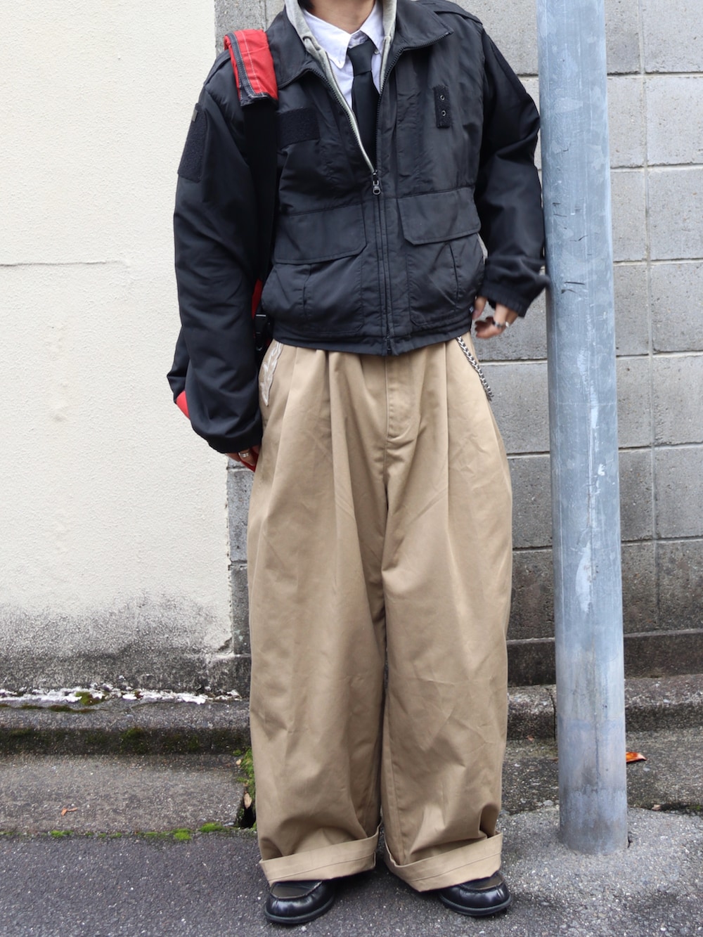 グレー系のパーカー、ブラック系のローファー、ベージュ系のチノパンツを着用したメンズの秋コーディネートの3枚目の写真