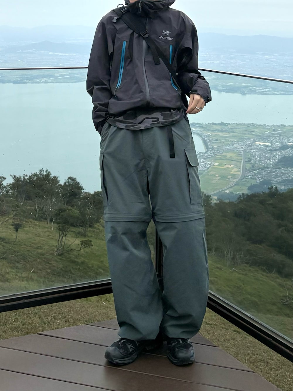 グレー系のTシャツ/カットソー、グレー系のマウンテンパーカー、グリーン系のカーゴパンツを着用したメンズの秋コーディネートの3枚目の写真