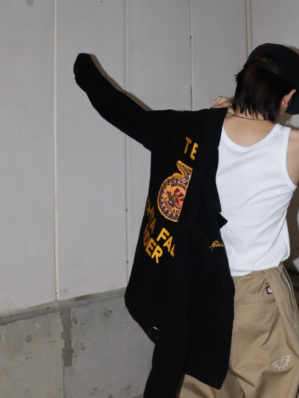 ブラック系のミリタリージャケット、ベージュ系のチノパンツ、ブラック系のブーツを着用したメンズの秋コーディネートの5枚目の写真