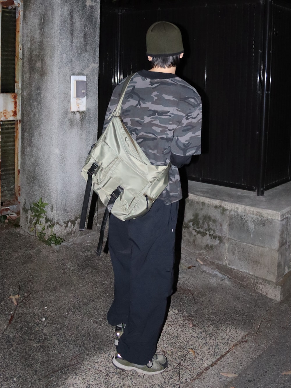 グリーン系のショルダーバッグ、ブラック系のカーゴパンツ、グレー系のTシャツ/カットソーを着用したメンズの秋コーディネートの3枚目の写真