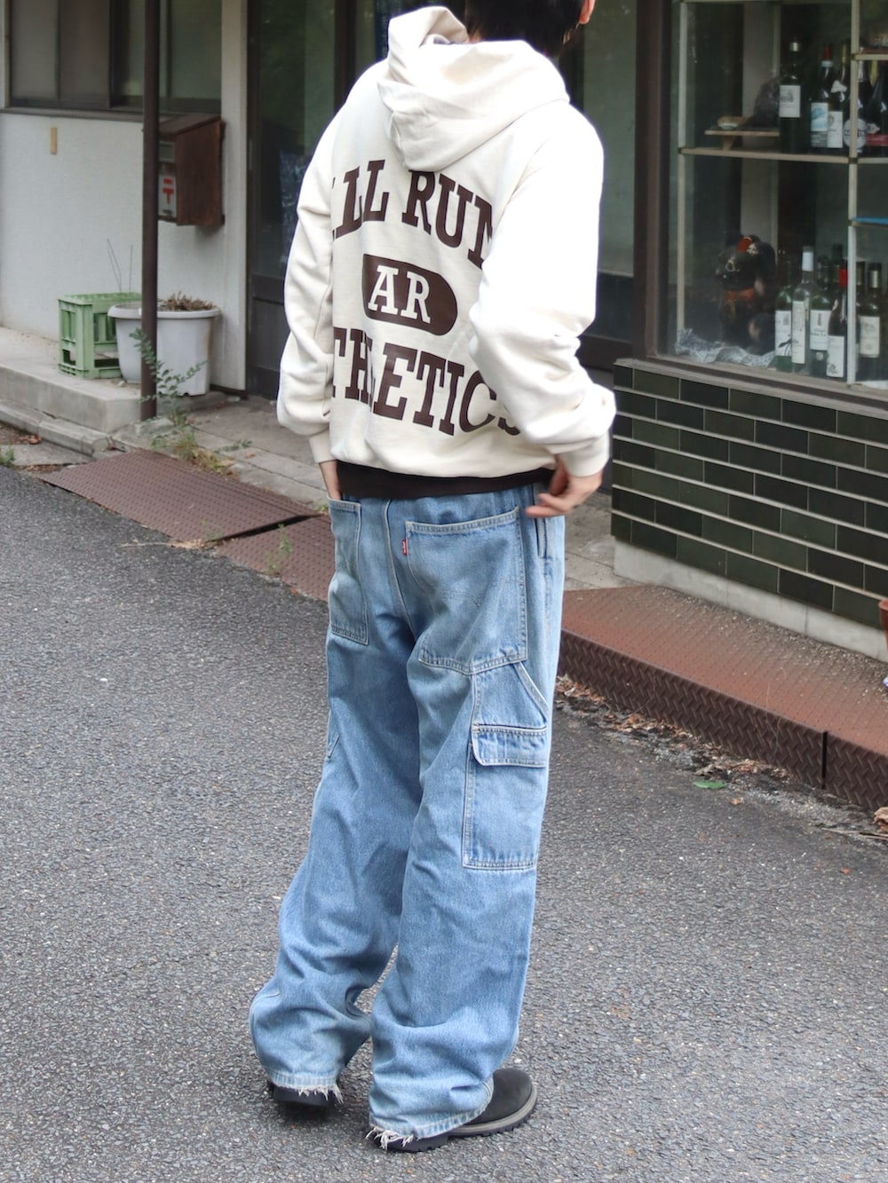 ベージュ系のパーカー、ブラウン系のTシャツ/カットソー、ブルー系のデニムパンツを着用したメンズの秋コーディネートの3枚目の写真