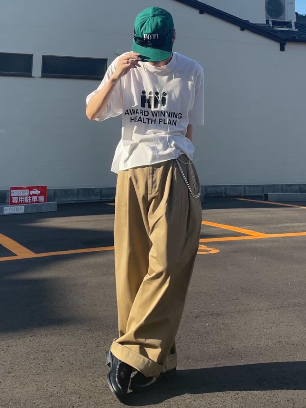 ベージュ系のチノパンツ、ホワイト系のTシャツ/カットソー、ブラック系のローファーを着用したメンズの夏コーディネートの3枚目の写真