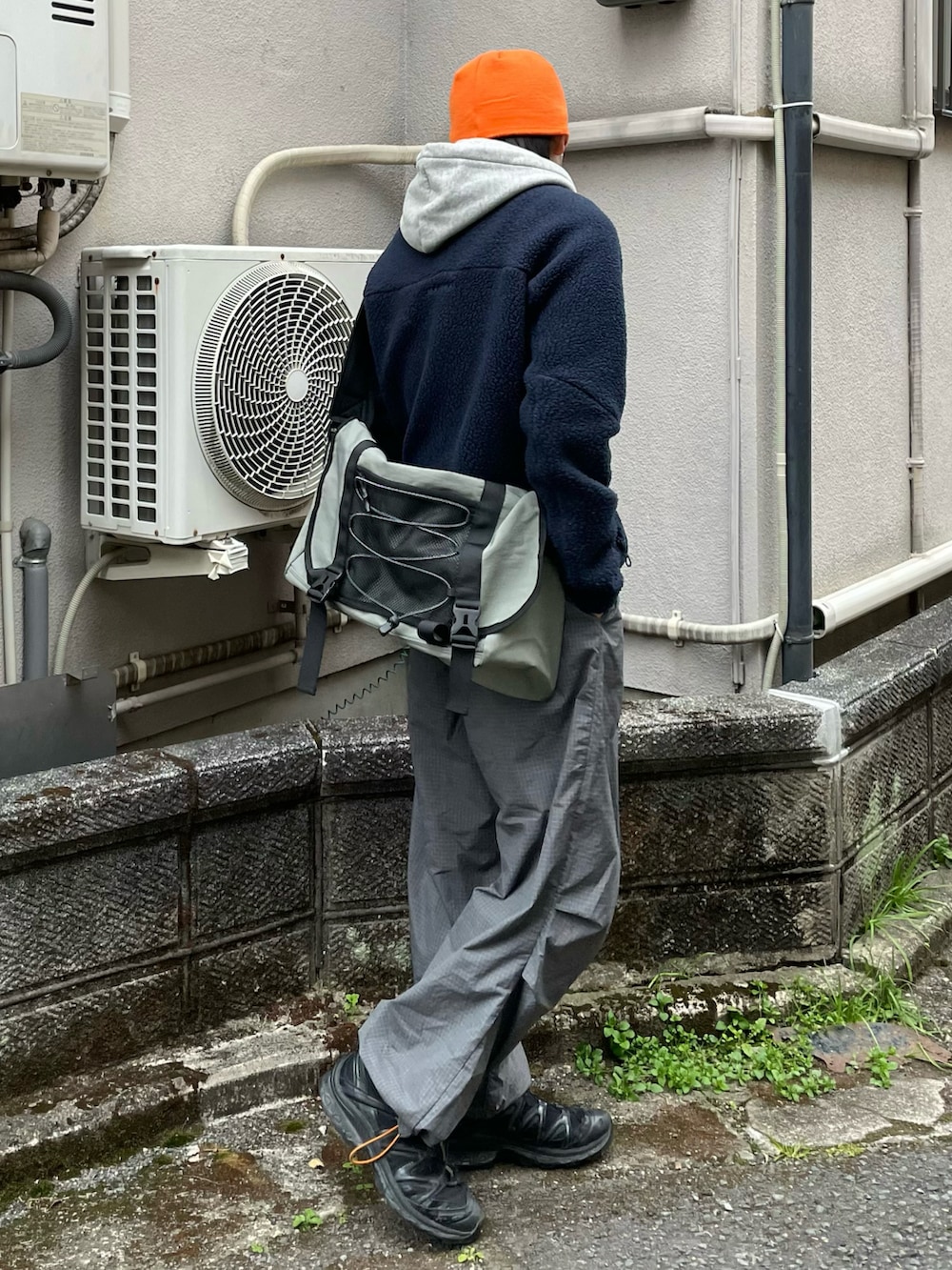 グレー系のメッセンジャーバッグ、グレー系のカーゴパンツ、ブラック系のスニーカーを着用したメンズの春コーディネートの3枚目の写真