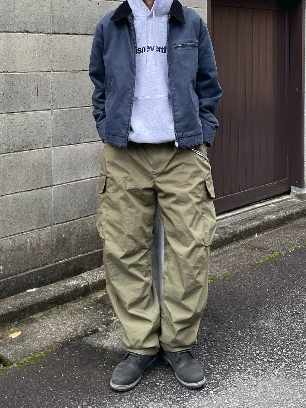 グレー系のパーカー、グリーン系のカーゴパンツ、ブラック系のブーツを着用したメンズの冬コーディネートの3枚目の写真